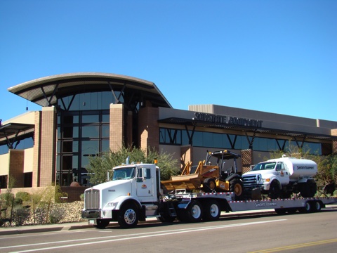 Rental construction equipment from Sunstate Equipment being transported to a customer